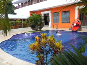 a man in a swimming pool next to a house at Hotel Puerto Libre in Puerto Barrios