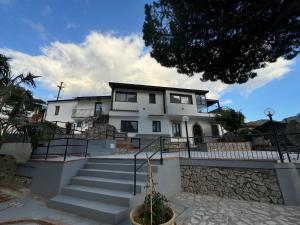 a large white house with stairs in front of it at B&B Villa Aura in Savoca 