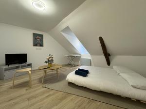 a bedroom with a bed and a tv and a table at Les lys beiges - 4pers - Rêve au Mans in Coulaines