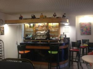 a bar in a restaurant with chairs around it at Hotel Bar Restaurant Couleurs Sud in Charleville-M&eacute;zi&egrave;res