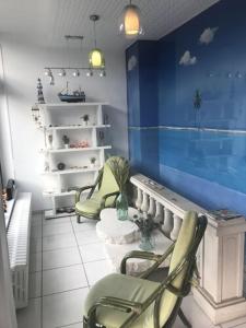 a room with two chairs and a blue wall at Hotel Bar Restaurant Couleurs Sud in Charleville-M&eacute;zi&egrave;res