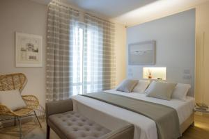 a bedroom with a bed and a chair and a window at Tosca With Beach & Breakfast Included in Viareggio