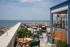 a balcony with tables and chairs and the ocean at Tosca With Beach & Breakfast Included in Viareggio