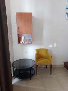 a living room with a table and a yellow chair at Božikovina Beach Rooms in Podstrana