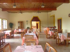 ein Restaurant mit Tischen, Stühlen und rosafarbenen Tischdecken in der Unterkunft Hotel Debliz Xpujil in Chicanna