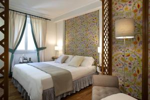 a bedroom with a large bed and a chair at Boheme With Beach & Breakfast Included in Viareggio +5 photos