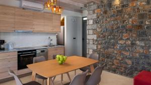 a kitchen with a wooden table and a brick wall at Family Rhodes Villa 4 Bedrooms Villa Summer Memories Private Pool Lindos in vlicha
