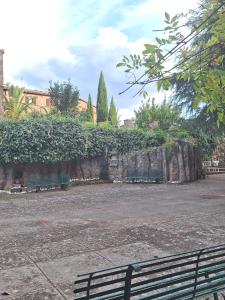 a park bench in front of a stone wall at Monastero San Lodovico - Orvieto in Orvieto