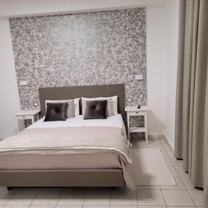 a bedroom with a large bed with a wall at House Torre Galea 2 in Marina di Gioiosa Ionica