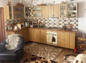 a kitchen with wooden cabinets and a chair in it at Casa Armonia in Bran +36 photos