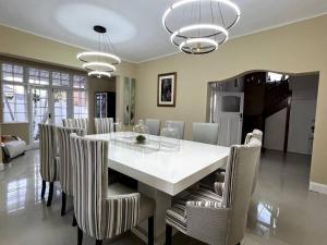 a dining room with a white table and chairs at Pearlstone in Durban