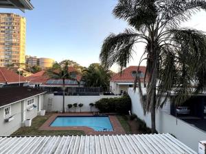a house with a swimming pool and a palm tree at Pearlstone in Durban +13 photos