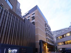 a tall building in a city with tall buildings at Dormy Inn Premium Shibuya-jingumae in Tokyo