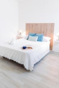 Apartamento El EnTorno في Valle de Abdalagís: غرفة نوم بسرير أبيض كبير مع وسائد زرقاء