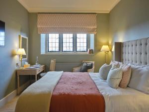 a hotel room with a large bed and a desk at Castle Hotel in Taunton +62 photos