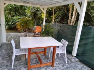 a white table and two chairs on a patio at Chez Clo in Le Gosier +4 photos