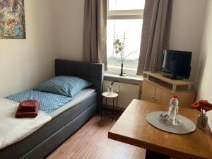 a small living room with a bed and a table at Kulinarische Zauberei in Rathenow