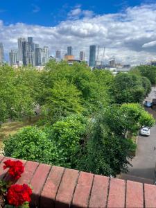 a view of a city from a balcony with flowers at Charming and Cosy Canary Wharf Room with Stunning Views in London