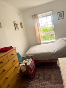 a bedroom with a bed and a dresser and a window at Charming and Cosy Canary Wharf Room with Stunning Views in London