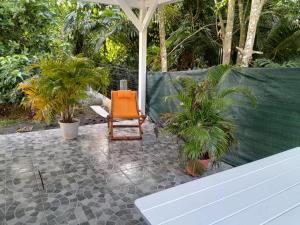 an orange chair sitting on a patio with plants at Chez Clo in Le Gosier