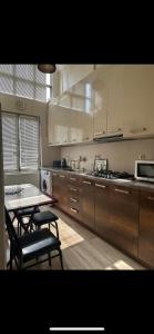 a kitchen with wooden cabinets and a table and chairs at Sweet Home Agmashenebeli in Tbilisi City