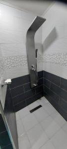 a shower in a bathroom with black and white tiles at Maison de vacances vue sur la mer in Mazer