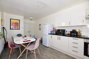 a kitchen with a table and a white refrigerator at Cliftonville Approach in Margate