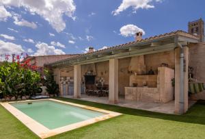an outdoor kitchen and swimming pool in a house at 271 Cas Padri Teco ETV6178 by Mallorca Charme in Ariany