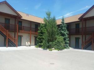 a large building with trees in front of it at Teton Valley Motel in Victor