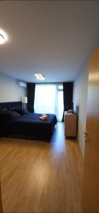 ラズロクにあるAspen Suites Luxury apartment A005のウッドフロアのベッドルーム1室(黒いベッド1台付)