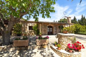a stone house with flowers in front of it at 273 Villa Joy ETV99 by Mallorca Charme in Llubí