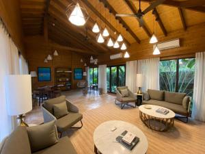 a living room with couches and chairs and tables at The Postcard Hideaway, Netravali Wildlife Sanctuary, South Goa in Vichondrem