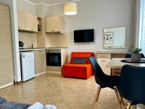 Una sala de estar con una silla roja y una cocina. en Royal sun Premium Apartment, en Sunny Beach