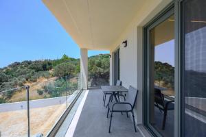 a balcony of a house with a table and chairs at Villa Katerina 1 in Marioú