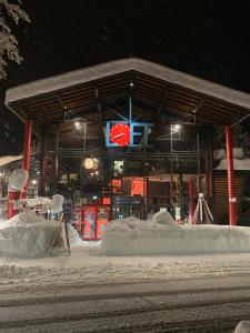 a building with snow piled up around it at night at Studio im Loft in Oberstdorf +8 photos
