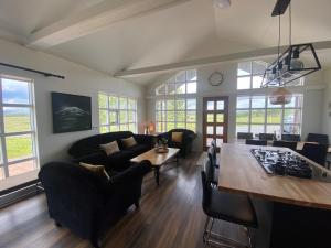 a living room with a couch and a table and chairs at Myrarkot Country Home in Selfoss