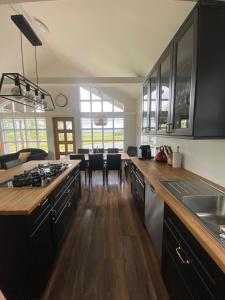 a kitchen with black cabinets and a dining room at Myrarkot Country Home in Selfoss
