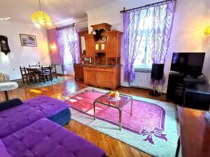 a living room with a purple couch and a table at Apartman Villa Adelina in Lovran