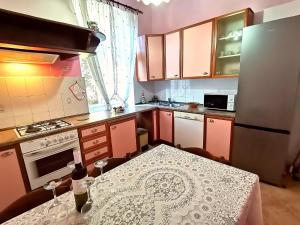 a kitchen with a table with wine glasses on it at Apartman Villa Adelina in Lovran