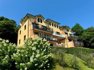 a building on a hill with trees in front of it at Lago Bello in Stresa
