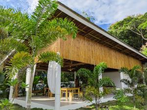 a tropical house with a wooden roof at MHARI Bungalows and Rooms in Tubod