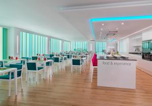 a restaurant with tables and chairs and a food and experience sign at H10 Gran Tinerfe - Adults Only in Adeje