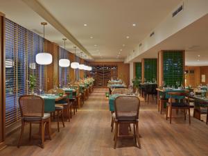 a restaurant with tables and chairs and windows at H10 Gran Tinerfe - Adults Only in Adeje