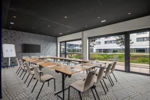 a conference room with a long table and chairs at Hyatt Place Paris Charles de Gaulle Airport in Roissy-en-France