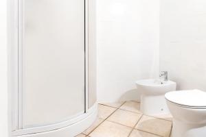 a white bathroom with a shower and a toilet at Villa Costa Smeralda Golfo di Marinella AC e WiFi in Golfo Aranci