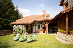 a group of chairs sitting on the grass in front of a house at Doberek Noclegi w Beskidzie Niskim in Kobylanka