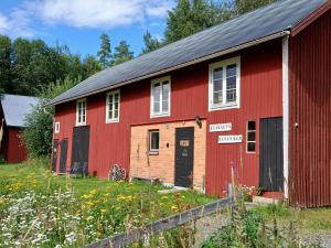 a red barn with a black roof at B&B Klarälvsbanan in Deje