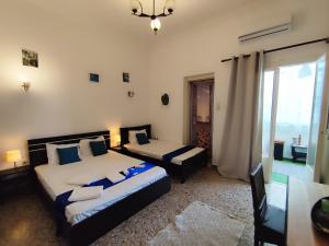 a bedroom with two beds and a chandelier at Cozy room in quiet neighbourhood in Athens