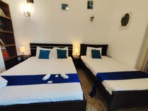 two beds in a room with blue and white at Cozy room in quiet neighbourhood in Athens +39 photos