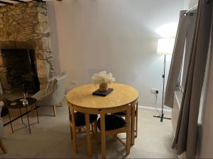 un tavolo e sedie in un soggiorno con camino di The Cosy Cottage a Llanberis